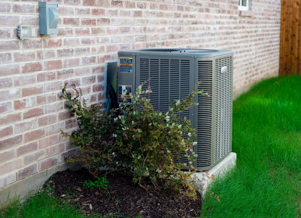 Outdoor air conditioner unit and electrical disconnect box on the side of a home