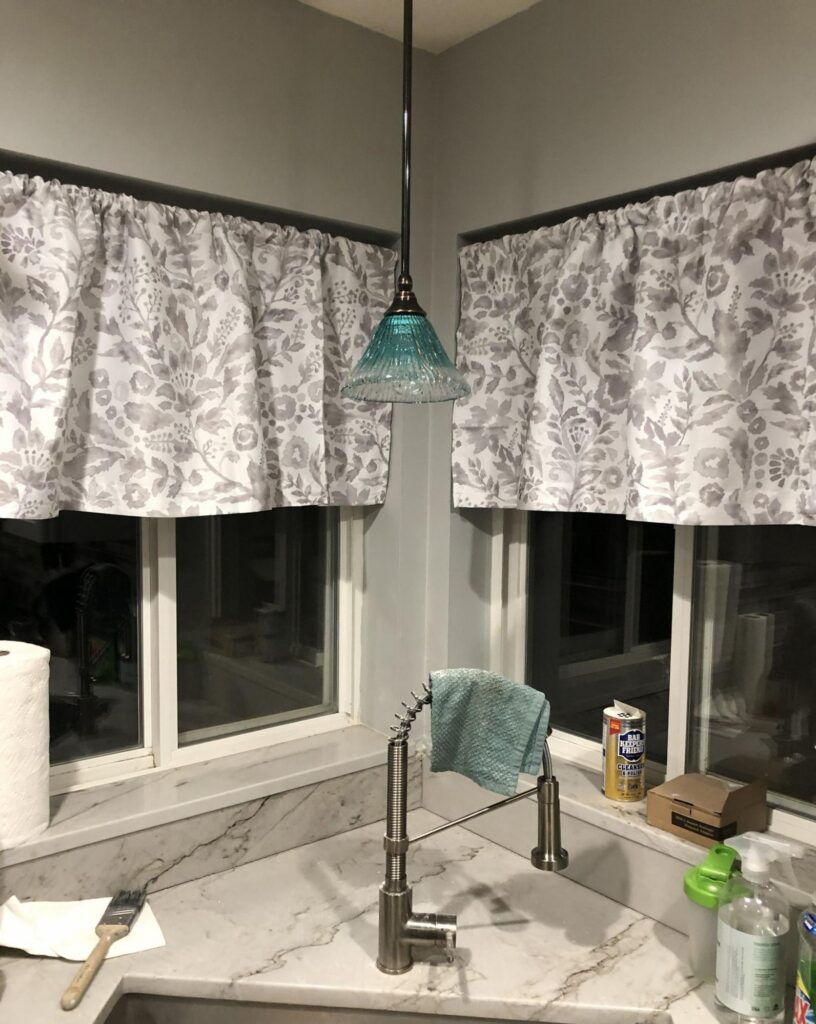 A blue glass pendant light installed over a kitchen sink as part of home electrical services in Boise, ID.